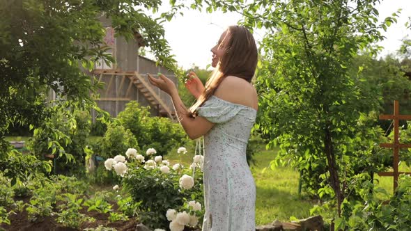 Woman Touching Tree Branches in Garden