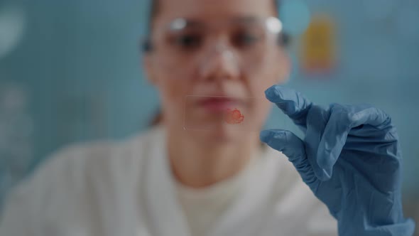 Woman Biologist Analyzing Blood Sample on Glass Tray