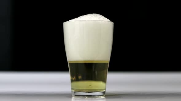 Close Up Background of Pouring Beer with Bubbles and Foam in Glass Low Angle View