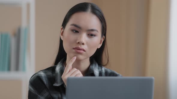 Thinking Student Girl Asian Pensive Woman Portrait Sits in Front of Laptop Doing Online Task Looking