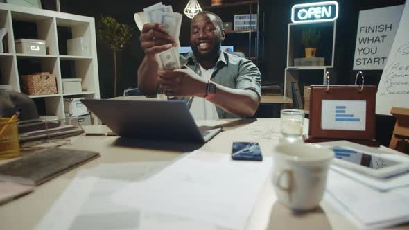 Successful African Businessman Counting Money in Hipster Office in Slow Motion.