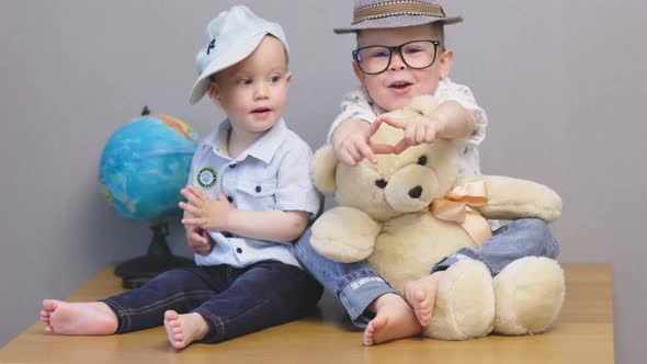 Happy Funny Caucasian Toddler Kids Boys Playing Enjoying Teddy Bear Globe Hat