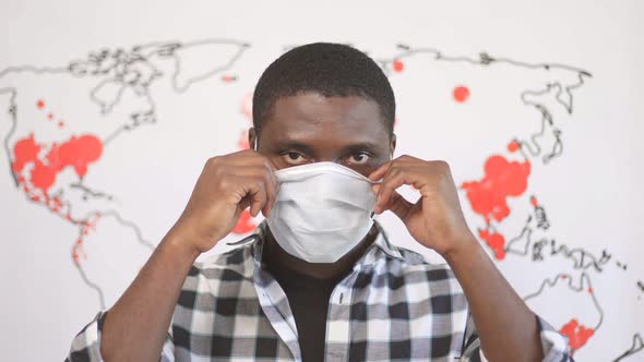 African American Male in Medical Mask and World Map That Shows Spreading of Coronavirus