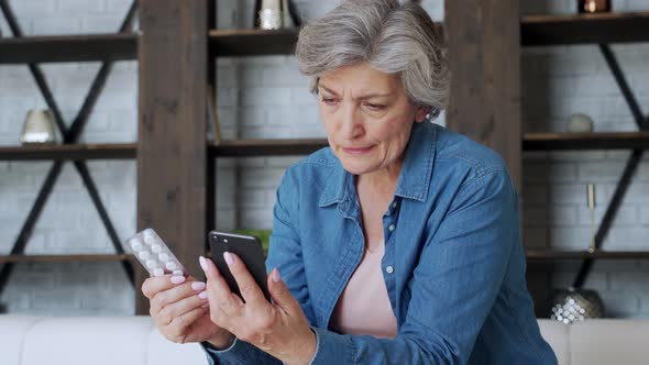 Elderly Woman Checks the Recipe Using Her Smartphone. Holds a Smartphone in One Hand and Pill in the