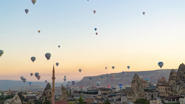 Zoom out timelapse of hot air balloons flights at sunrise in Goreme, Cappadocia, Turkey