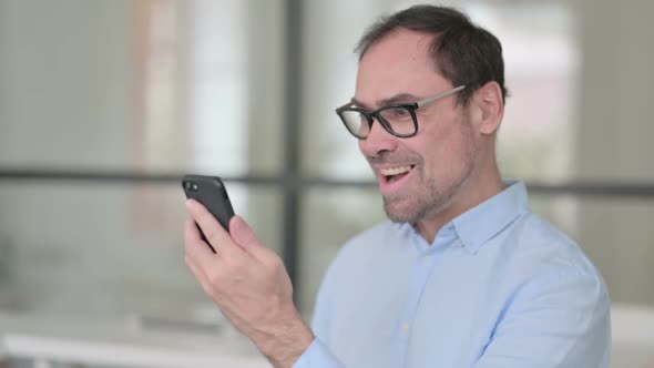 Middle Aged Man Celebrating on Smartphone