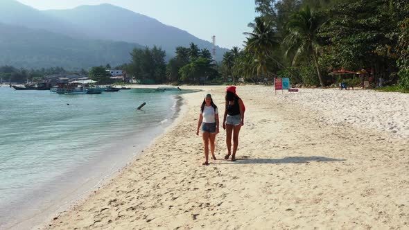 Beautiful ladies best friends on paradise coastline beach lifestyle by blue ocean and white sandy ba