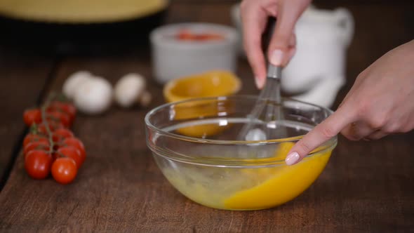 Close up woman hand beat eggs in kitchen.