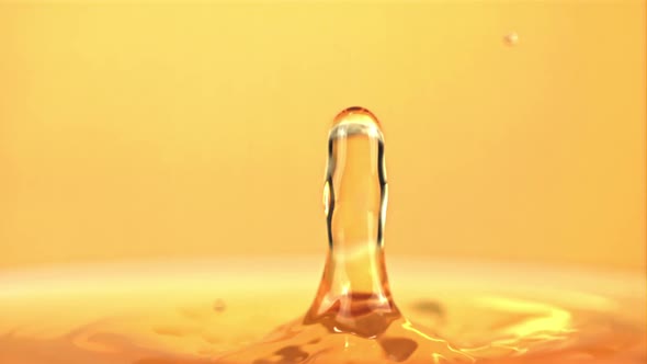 The Super Slow Motion Drop Falls Into the Apple Juice with Splashes