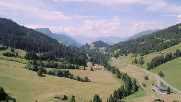 Aerial View of a Valley in Switzerland with Chalets and a Mountainous Landscape