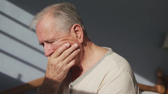 Senior man lying on bed at home