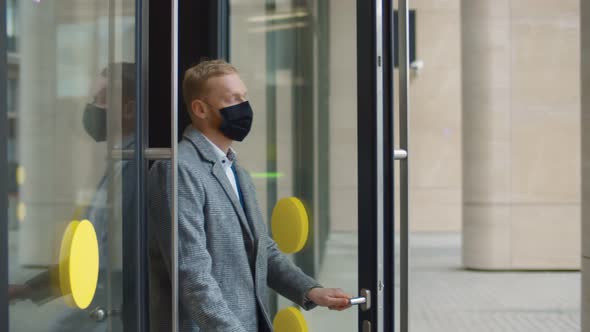 Young Businessman Exiting Business Center and Removing Face Mask