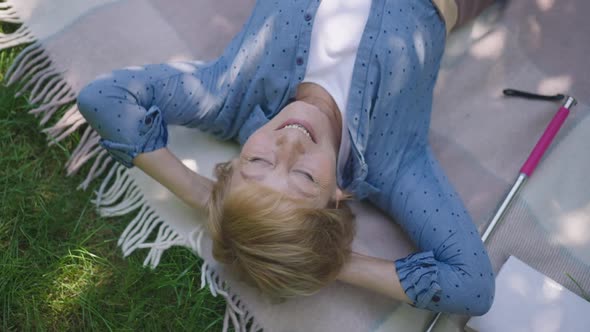 Carefree Senior Woman Lying with Hands Behind Head Smiling Looking Up