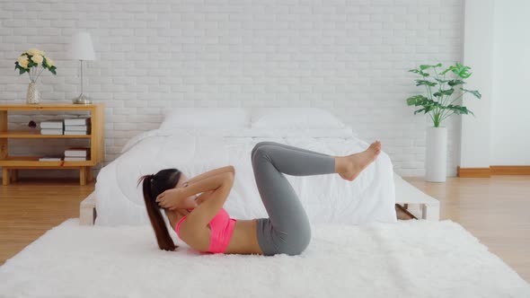 Athletic Healthy Asian woman in sportswear workout excercise at home