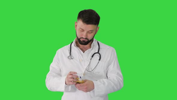 Arab Doctor Counting Money EUROs on a Green Screen, Chroma Key