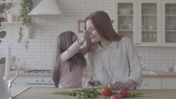 Portrait Young Mother and Her Little Daughter in the Big Kitchen