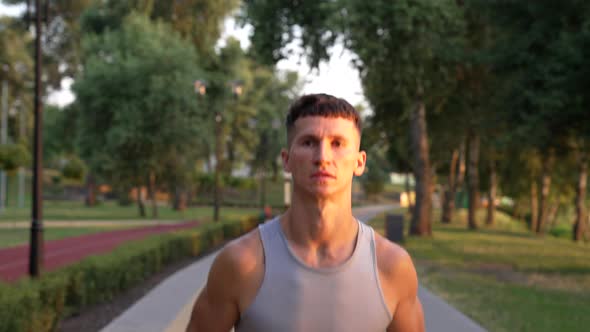 Young Athletic Man Running in the Morning Outdoor Facing Sunrise Workout