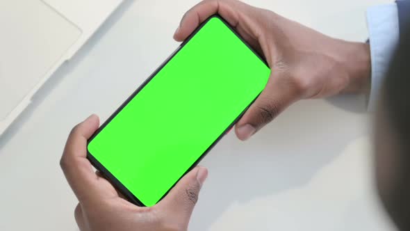 Top View of Holding Smartphone with Green Chroma Key Screen