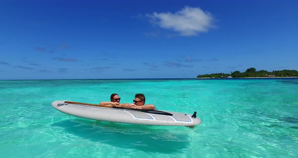 Happy boy and girl on honeymoon vacation live the dream on beach on sunny white sandy background