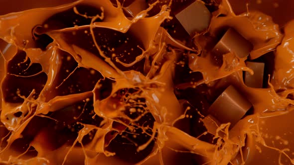 Super Slow Motion Shot of Caramel Chunks Falling Into Melted Caramel at 1000Fps