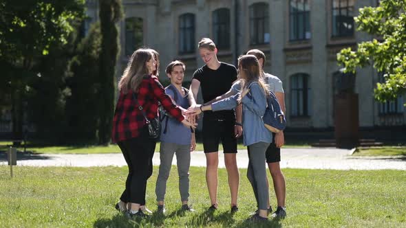 Happy College Students with Hands in Stack