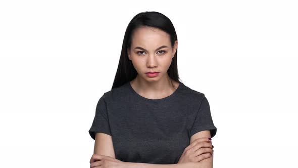 Portrait of Serious Brunette Asian Woman with Long Black Hair Holding Index Finger on Lips and