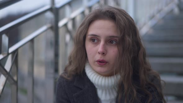 Closeup Portrait of Anxious Stressed Young Beautiful Woman Thinking Sitting on Urban Stairs on