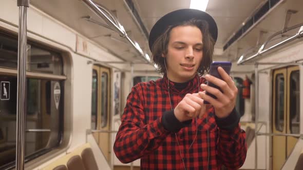 Young handsome stylish man wearing black hat with headphones listening to music