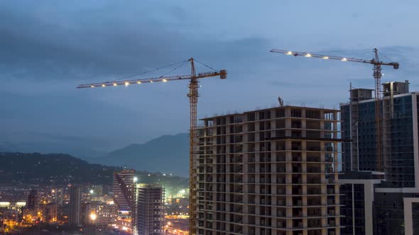 Building Construction From Day To Night. Timelapse. Tower Crane with Lighting on a Construction Site