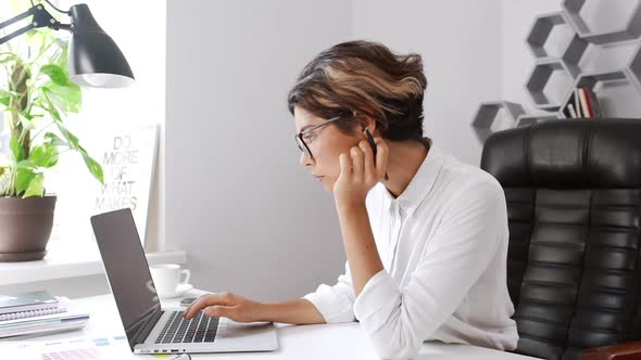 Beautiful Businesswoman Typing on Laptop Sitting in Armchair Office Slow Motion