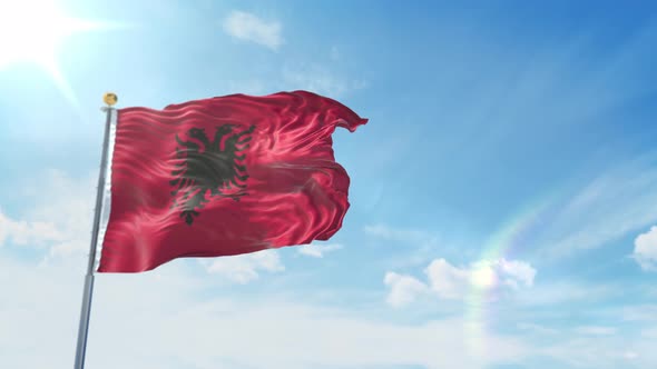 Albanian flag waving at wind with blue sky 