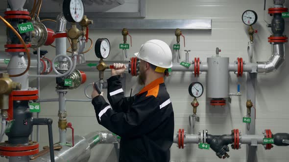 The Engineer Checks the Position of the Valves on the Pipeline and the Readings of the Pressure