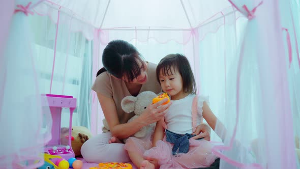 Asian beautiful parent, mother play education game with kid to learn and develop skill in tent.