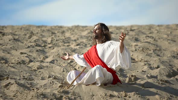 Monk in Lotus Pose Raising Hands to Sky, Praying to God in Desert, Meditation