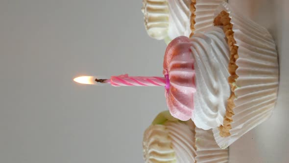 Birthday Cupcakes with Candles and Birthday Decorations on a Light Background