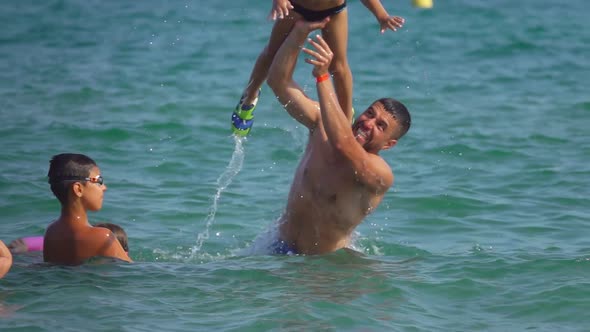 Boy Jumps Into Sea From Hands of an Older Brother