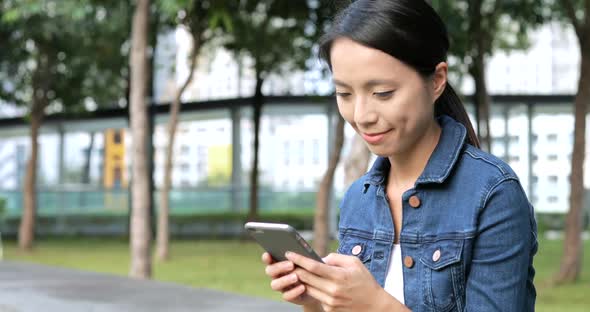 Woman using cellphone at outdoor park 