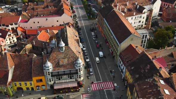 Aerial drone view of Sighisoara, Romania. Roads with cars, greenery and buildings