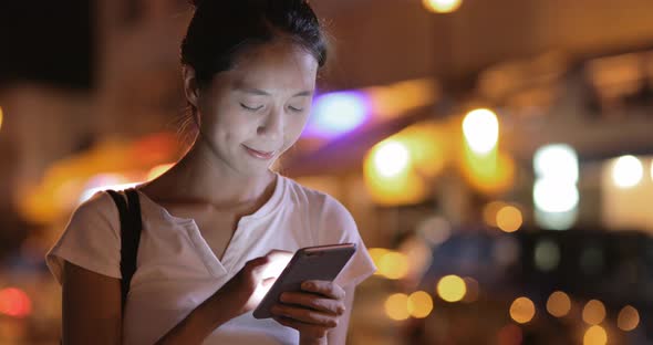 Woman using cellphone in the evening 