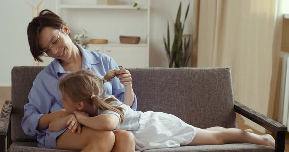 Two People Young Mother in Glasses and Cute Little Preschool Girl Daughter Sitting on Sofa Furniture