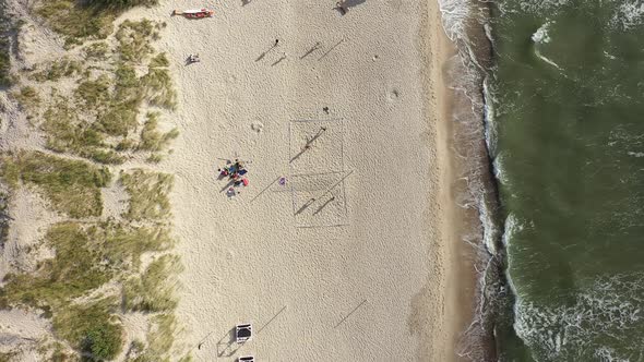 AERIAL: Young People Plays Volleyball on a Sand near Sea in Nida