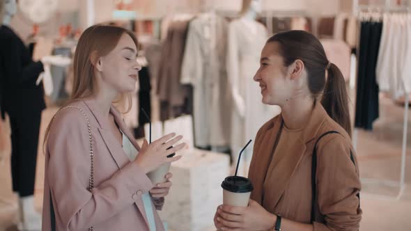 Happy Female Friends Chatting in Clothes Store