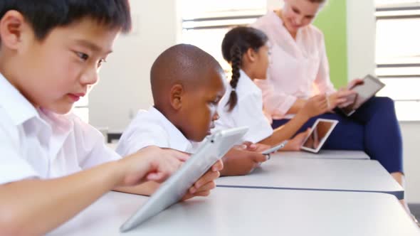 School kids and teacher using digital tablet in classroom