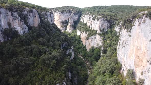 Aerial drone footage of the view of a mountainous natural cliffs and bright landscape.
