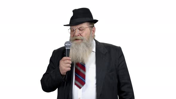 Old Businessman with Beard Talking Into Microphone