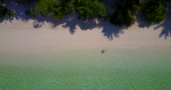 Natural above travel shot of a summer white paradise sand beach and aqua blue water background in co