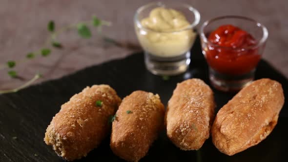 Spreading green parsley on fresh dough balls filled with sausage and cheese