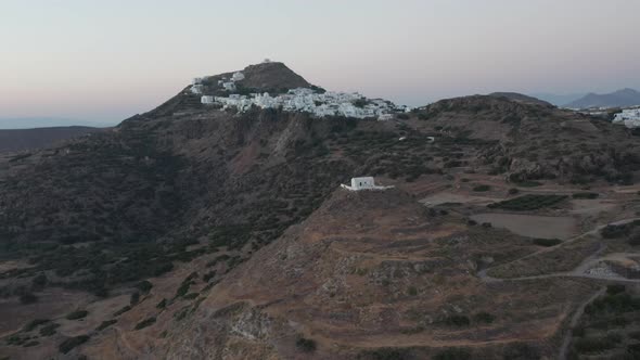 Aerial View Over Island with Church on Hill at Dusk