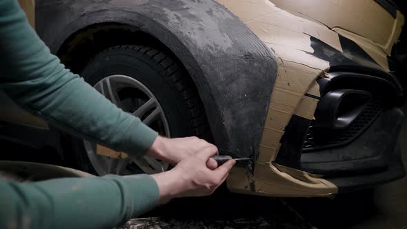 Worker Is Shaping Clay Detail on Car Body in Garage Projecting Tuning for Auto Working By Plastic