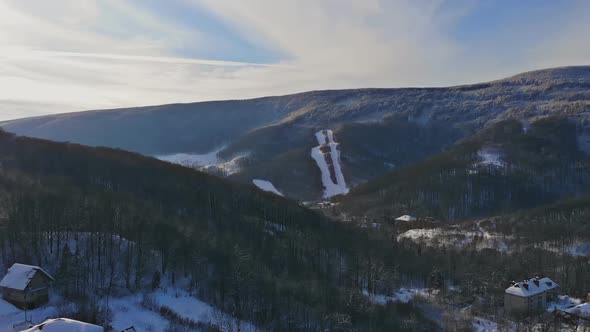 Rural landscape in the mountains in winter. Snow-covered houses in the snow from